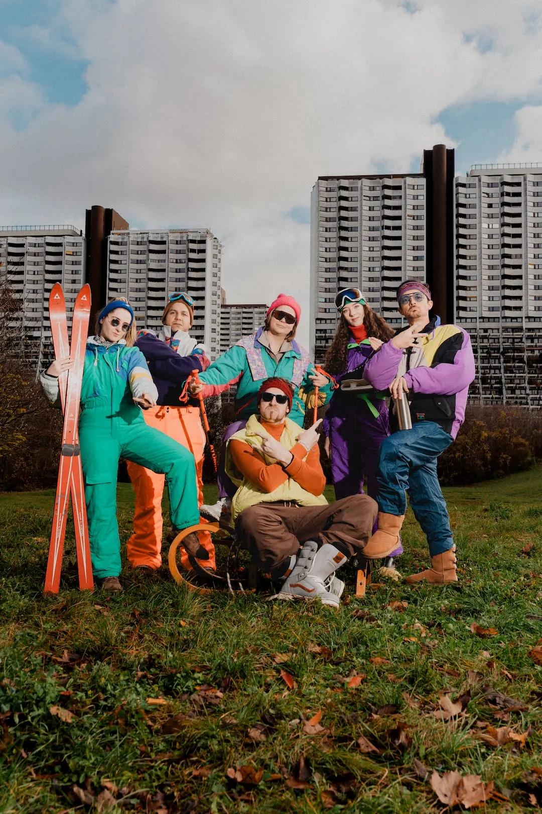Lowfidelity Team in Vintage Kleidung auf einer grünen Wiese vor Alterlaa. Über den Personen steht Besinnliche, weiße Weihnacht.