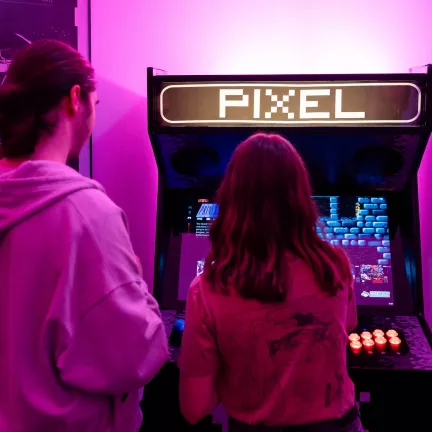 drupal meetup interessierte meschen im gespräch vor einem arcade computer